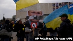 En numerosas manifestaciones contra la invasión de Rusia a Ucrania, los carteles comparan al presidente ruso Vladimir Putin con Hitler. (AP/Maya Alleruzzo)